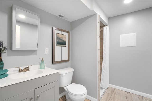 bathroom featuring walk in shower, vanity, and toilet