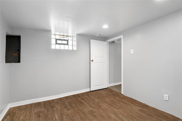 basement with wood-type flooring and electric panel