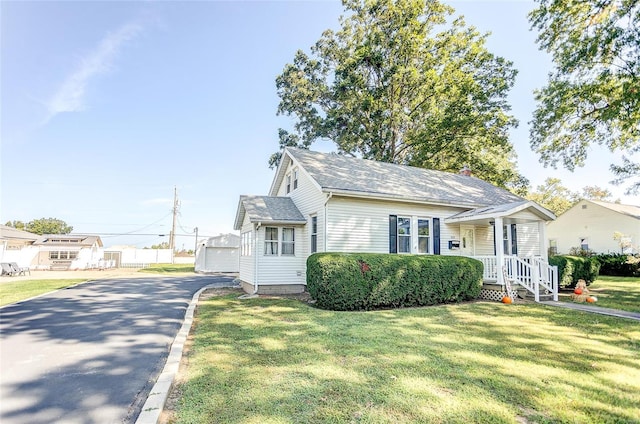 view of front of house featuring a front yard, an outbuilding, and a garage