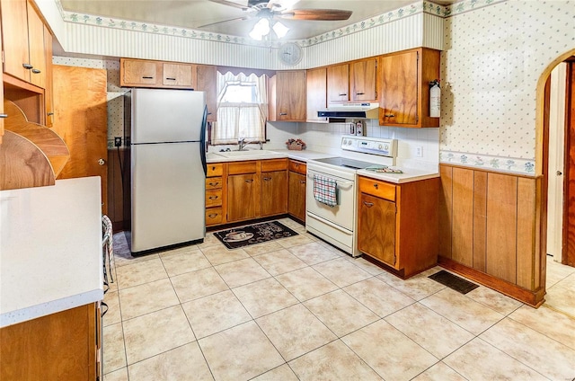 kitchen featuring ceiling fan, white appliances, sink, and light tile patterned floors