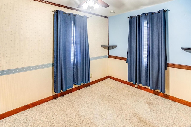 carpeted spare room with ceiling fan