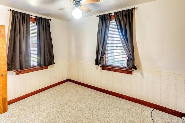 spare room with ceiling fan and carpet