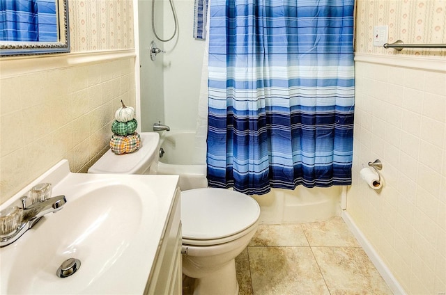 full bathroom with shower / tub combo with curtain, sink, tile walls, tile patterned flooring, and toilet