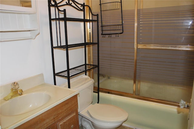 full bathroom featuring enclosed tub / shower combo, vanity, and toilet