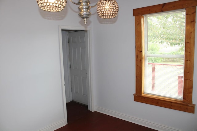 empty room with an inviting chandelier and plenty of natural light