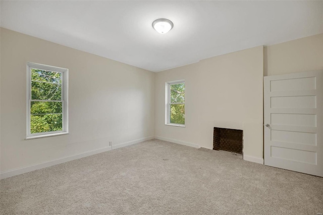 unfurnished living room with light carpet and a wealth of natural light