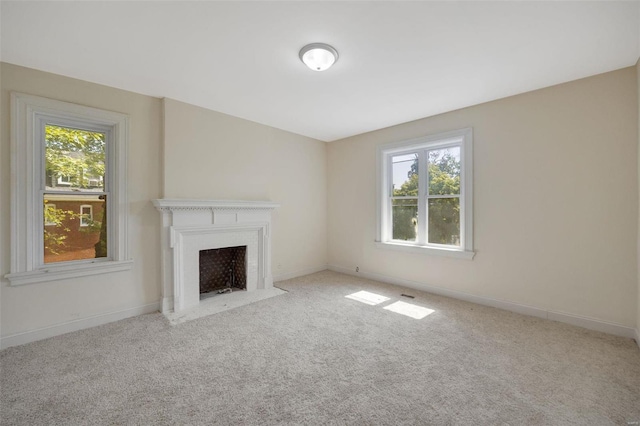 unfurnished living room featuring light colored carpet and plenty of natural light