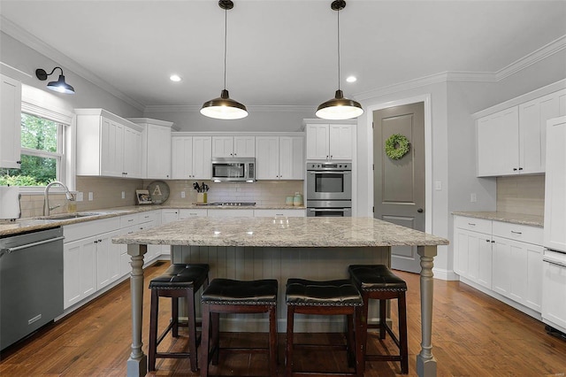 kitchen featuring white cabinets, a kitchen island, sink, and appliances with stainless steel finishes