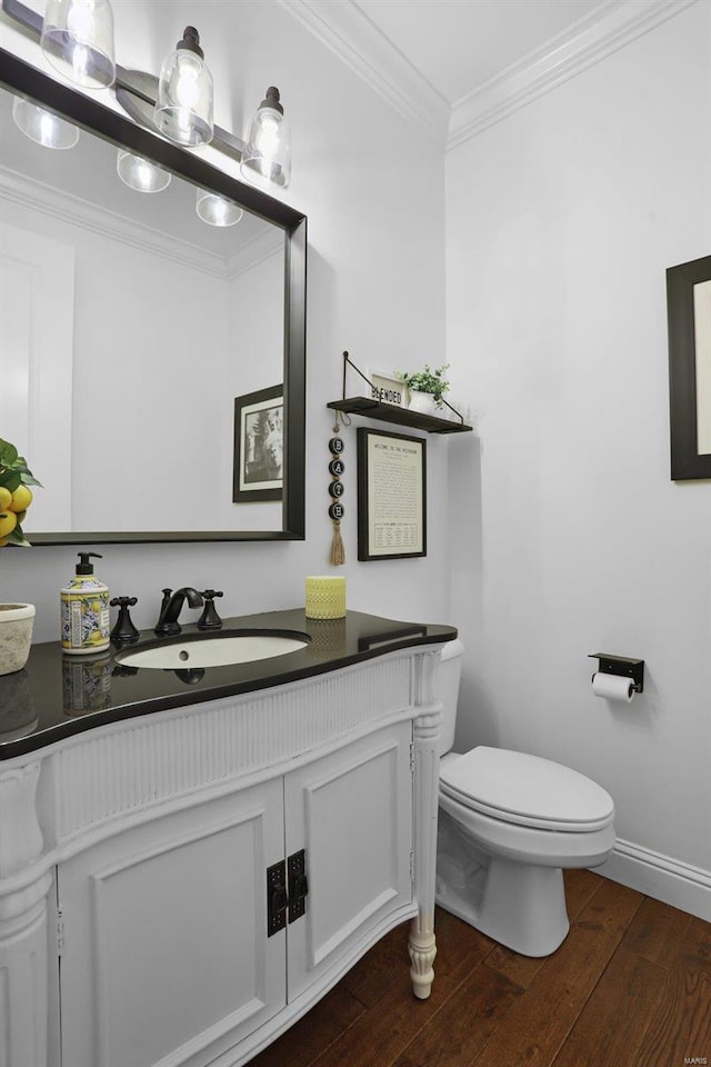 bathroom with vanity, toilet, wood-type flooring, and ornamental molding