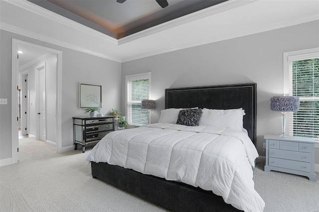 bedroom with a raised ceiling, ceiling fan, crown molding, and light carpet