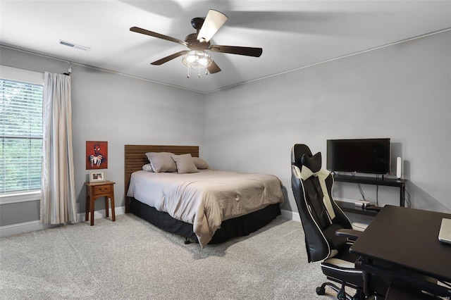 carpeted bedroom with multiple windows and ceiling fan