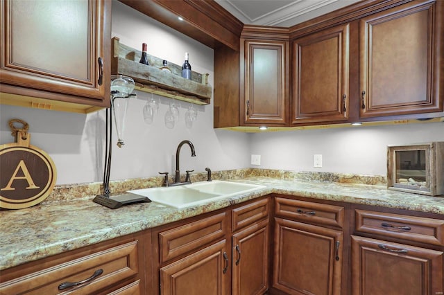 kitchen with crown molding, sink, and light stone counters