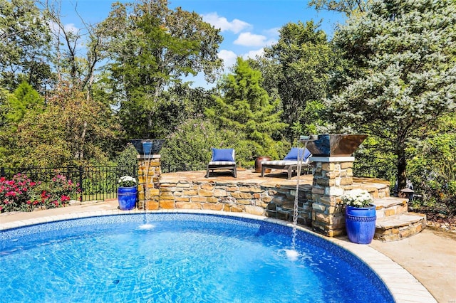 view of swimming pool featuring pool water feature and a patio