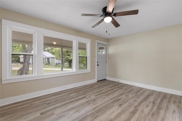 spare room featuring light hardwood / wood-style floors, ceiling fan, and a wealth of natural light