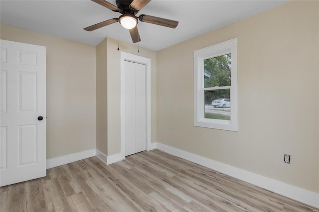 unfurnished bedroom with a closet, light hardwood / wood-style floors, and ceiling fan