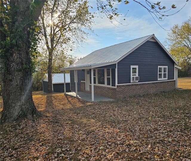 rear view of house featuring a patio area, a garage, and an outbuilding