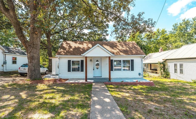 bungalow featuring covered porch and a front yard