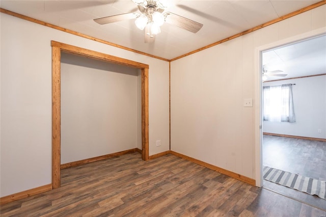 empty room with ceiling fan, ornamental molding, and dark wood-type flooring