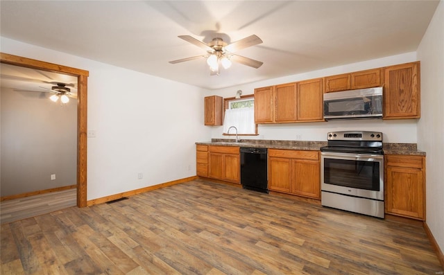 kitchen with ceiling fan, stainless steel appliances, dark hardwood / wood-style floors, and sink