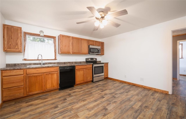 kitchen featuring dark hardwood / wood-style flooring, ceiling fan, appliances with stainless steel finishes, and sink