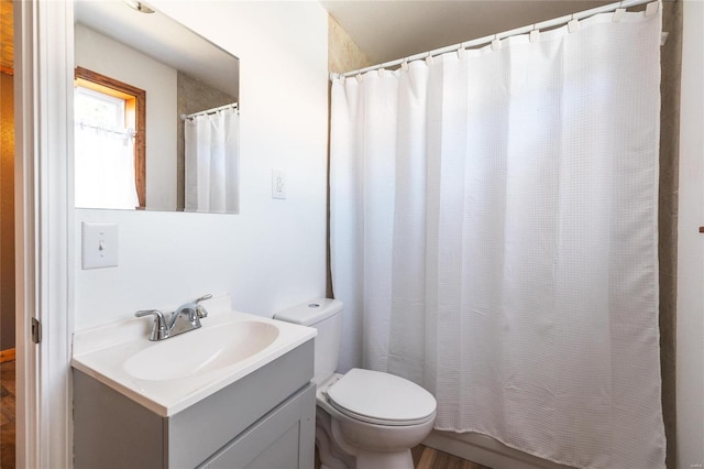 bathroom featuring walk in shower, vanity, hardwood / wood-style floors, and toilet