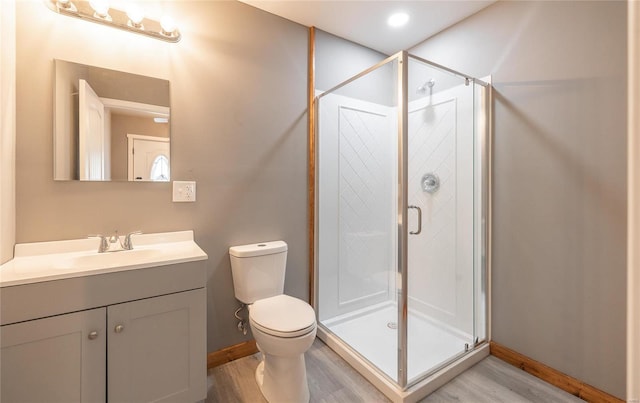 bathroom with walk in shower, vanity, toilet, and hardwood / wood-style flooring