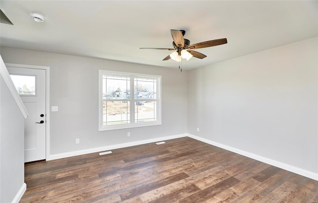 unfurnished room with ceiling fan, dark wood-type flooring, and a wealth of natural light