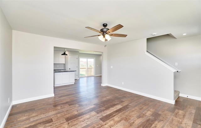 unfurnished living room with dark wood-style flooring, recessed lighting, stairway, ceiling fan, and baseboards