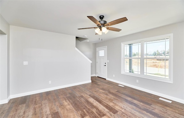 interior space with ceiling fan, visible vents, baseboards, and wood finished floors