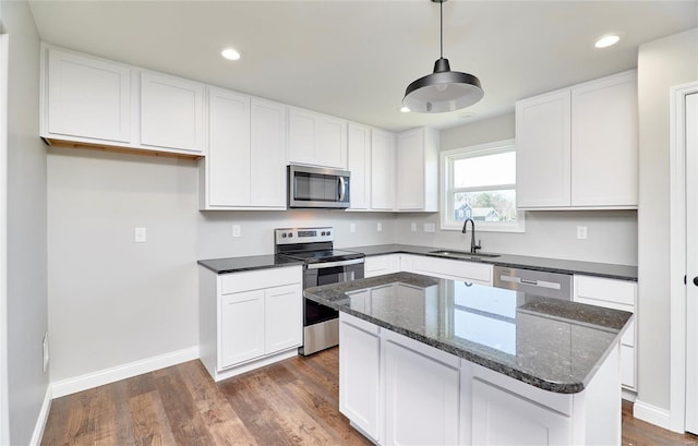 kitchen with stainless steel appliances, a sink, dark wood finished floors, and white cabinets