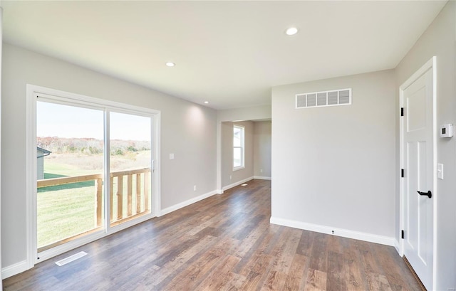 spare room with recessed lighting, wood finished floors, visible vents, and baseboards