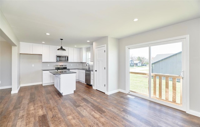 kitchen with white cabinets, dark wood-style flooring, stainless steel appliances, and a sink