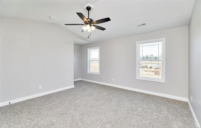 carpeted spare room with vaulted ceiling, ceiling fan, visible vents, and baseboards