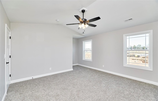 carpeted empty room featuring vaulted ceiling, a ceiling fan, visible vents, and baseboards