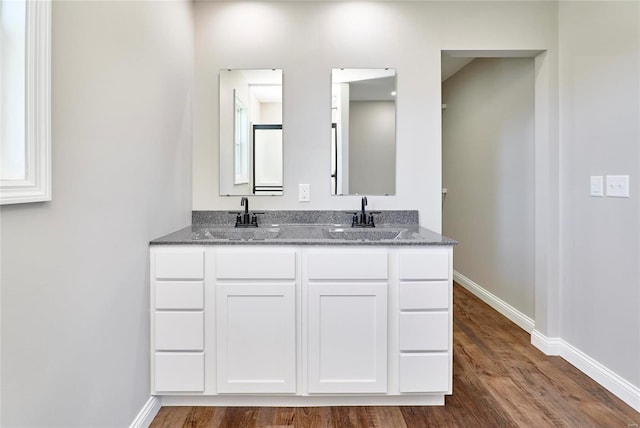 bathroom with a sink, baseboards, and wood finished floors