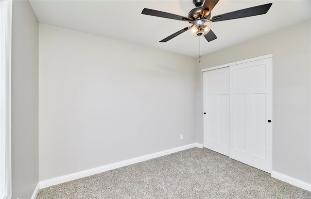 unfurnished bedroom with a closet, light colored carpet, ceiling fan, and baseboards