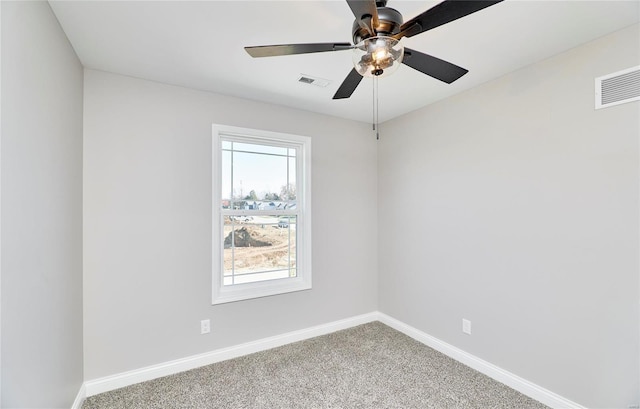 carpeted spare room with ceiling fan, visible vents, and baseboards