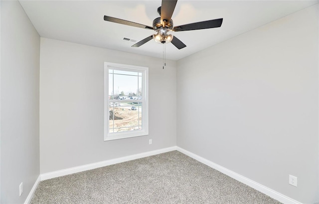 carpeted spare room with visible vents, ceiling fan, and baseboards