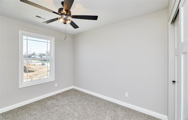 carpeted empty room with a ceiling fan, visible vents, and baseboards