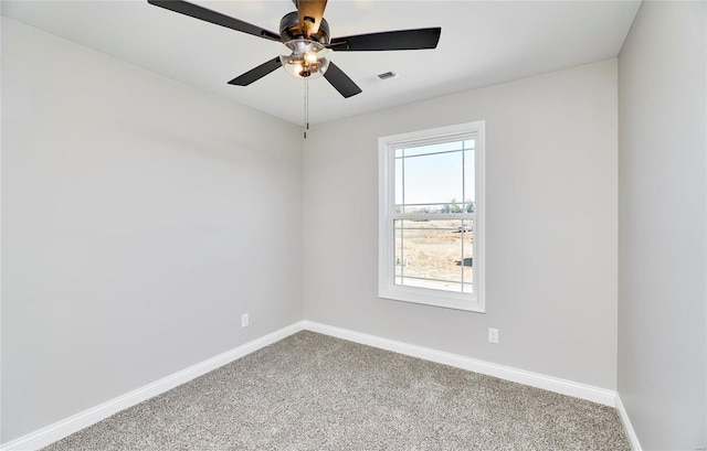 carpeted empty room with baseboards, visible vents, and a ceiling fan