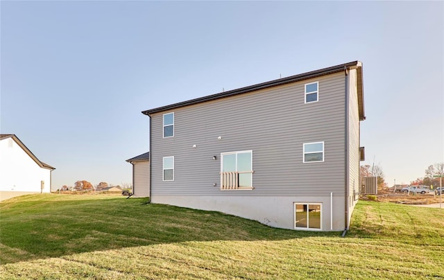 back of property featuring central AC and a lawn