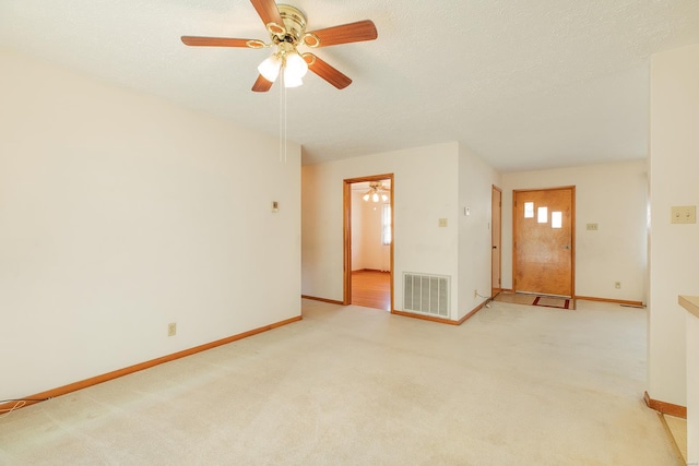 carpeted empty room with ceiling fan and a textured ceiling