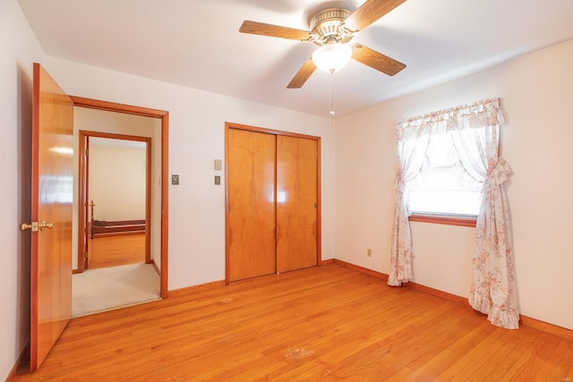 unfurnished bedroom featuring light hardwood / wood-style floors, ceiling fan, and a closet