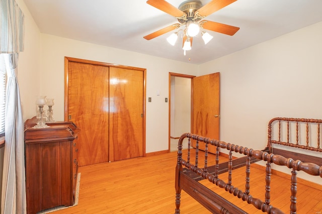 bedroom with ceiling fan, light wood-type flooring, and a closet