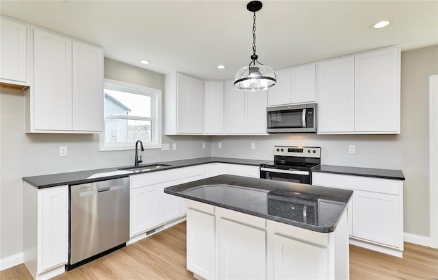 kitchen with stainless steel appliances, white cabinetry, and sink