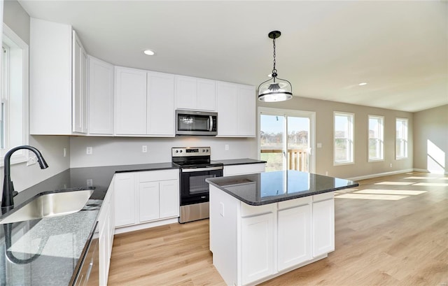 kitchen featuring appliances with stainless steel finishes, a center island, sink, and white cabinets