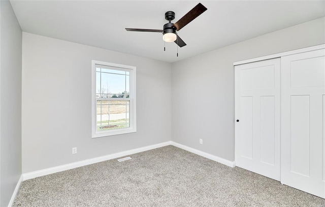 unfurnished bedroom featuring ceiling fan, a closet, and carpet floors