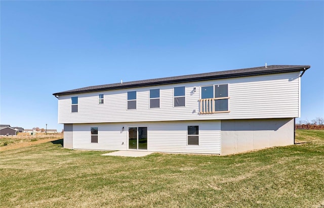 back of property with a yard and a patio area