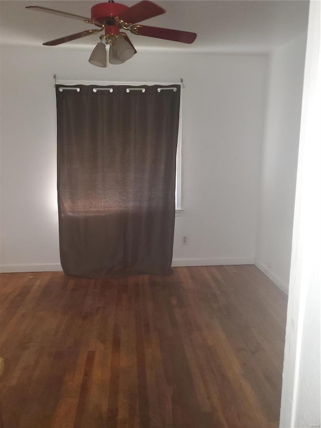 spare room with ceiling fan and dark wood-type flooring