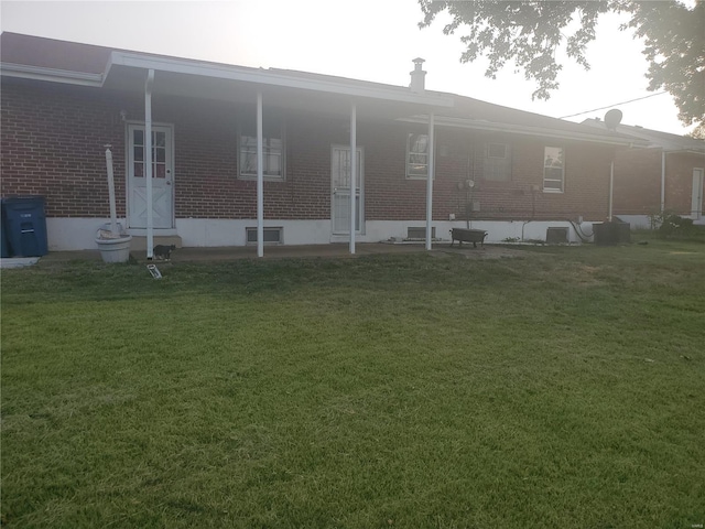 rear view of house featuring a yard